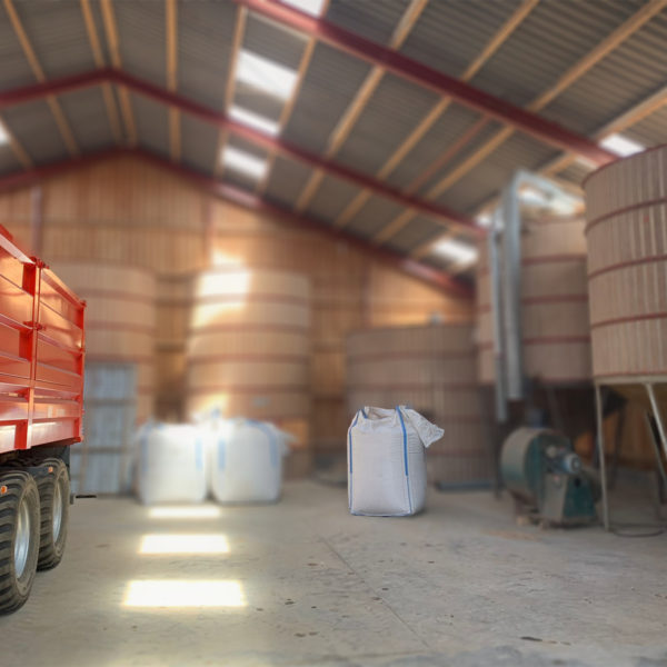 Grain silos inside a barn with a red wagon on the left side. At Lammehave ?kologi on Falster, Denmark.